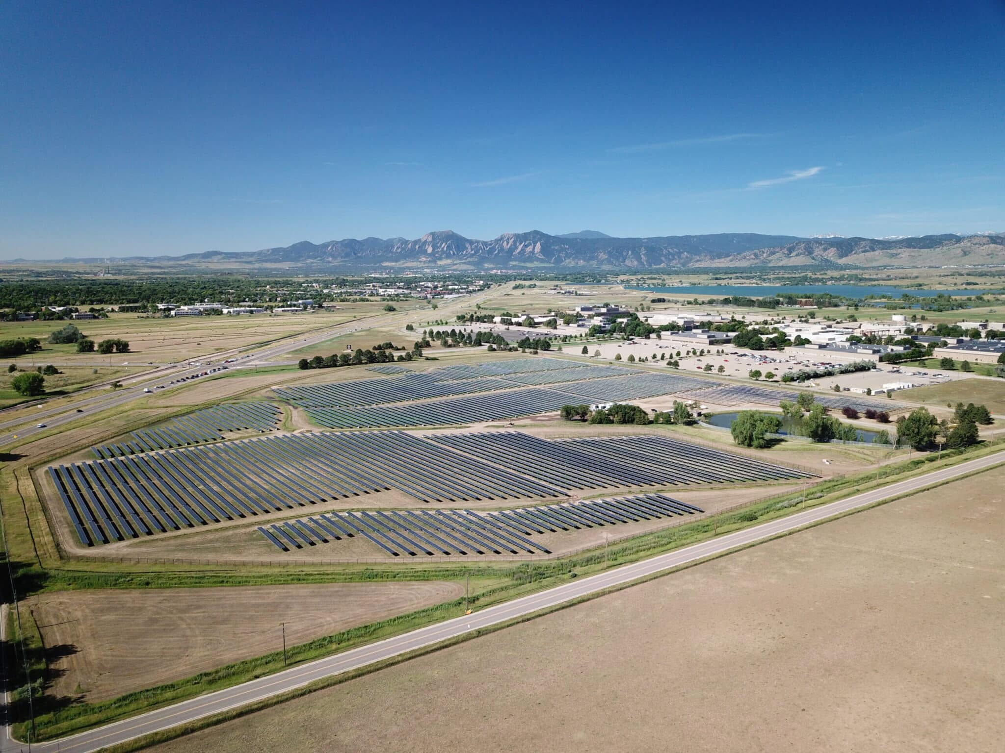commercial ground-mounted solar array in boulder flatirons in background